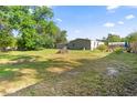 Expansive backyard with ample green space, mature trees, and a fenced perimeter at 26438 Glenwood Dr, Wesley Chapel, FL 33544