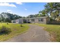 Charming single-story home featuring a curved driveway, well-maintained lawn and vinyl siding at 26438 Glenwood Dr, Wesley Chapel, FL 33544