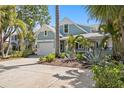 Charming two-story home with a well-manicured lawn, lush landscaping, and a welcoming front entrance at 2903 Pass A Grille Way, St Pete Beach, FL 33706