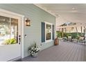 Inviting front porch featuring a stylish door, decorative lighting, a small garden, and cozy outdoor seating at 2903 Pass A Grille Way, St Pete Beach, FL 33706