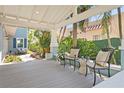 A cozy, covered porch with comfortable seating, lush greenery, and a view of the tranquil surroundings at 2903 Pass A Grille Way, St Pete Beach, FL 33706