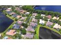 An aerial view of a community with mature trees and several homes with private pools on large lots along a lake at 3123 Whitehead Ln, Land O Lakes, FL 34638