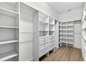Spacious walk-in closet with custom shelves, drawers, and wood floors for ample storage at 33487 Azalea Ridge Dr, Wesley Chapel, FL 33545