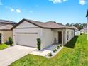 Charming single-story home featuring a well-manicured lawn and a two-car garage at 35552 Shade Fern Ln, Zephyrhills, FL 33541