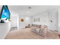 Bright living room features a large sectional sofa and a mounted TV at 35552 Shade Fern Ln, Zephyrhills, FL 33541