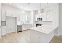 Modern kitchen with white cabinets, stainless steel appliances, and a spacious quartz countertop island at 448 31St N Ln, St Petersburg, FL 33713