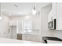 Contemporary kitchen featuring bright white cabinetry, stainless appliances, and stylish pendant lighting at 448 31St N Ln, St Petersburg, FL 33713
