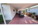 Covered parking area showcasing lush landscaping, a golf cart, and convenient access to the home at 4851 W Gandy Blvd # 23C, Tampa, FL 33611