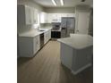 Modern kitchen featuring stainless steel appliances, white cabinetry, and an island at 5101 Corvette Dr, Tampa, FL 33624