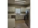 Well-lit kitchen with white cabinets, stainless steel appliances and ample counter space at 5101 Corvette Dr, Tampa, FL 33624