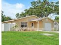 Inviting single-story home featuring a lush green lawn, quaint front porch, and an attached garage at 5542 19Th N Ave, St Petersburg, FL 33710