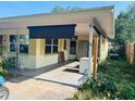 A partial shot of the carport. The house is painted yellow at 5805 Tennessee Ave, New Port Richey, FL 34652