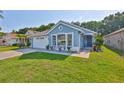 Charming single-story blue home with well-kept lawn, manicured shrubbery, and beautiful accents at 6232 Crickethollow Dr, Riverview, FL 33578