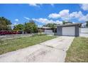 Charming home featuring a one-car garage, a long driveway, a well-kept yard, and a classic white picket fence at 702 Regent S Cir, Brandon, FL 33511