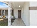 Inviting front porch with neutral tile, leading to a freshly painted front door, and manicured landscaping at 7123 Cherry Laurel Dr, Port Richey, FL 34668