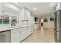 Bright kitchen features modern white cabinets, stainless steel appliances, granite countertops, and an open layout at 734 Lake Forest Rd, Clearwater, FL 33765