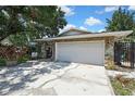 Spacious garage with stone accents and ample parking on a sunny day at 7924 Singing Court Pl, Tampa, FL 33615