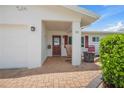 Inviting front porch featuring brick pavers, rocking chair, fire pit, and well manicured green hedges at 9226 41St N St, Pinellas Park, FL 33782