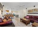 Spacious open-concept living room with tile floors, leather sofas, and seamless flow to kitchen and dining at 9226 41St N St, Pinellas Park, FL 33782