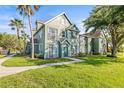 Well-manicured exterior of home with lush green lawn, sidewalk, and mature trees providing shade at 9416 Lake Chase Island Way # 9416, Tampa, FL 33626