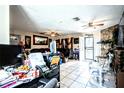 Bright living room with tile flooring, ceiling fans, a stone fireplace, and multiple entryways at 11411 N 19Th St, Tampa, FL 33612