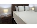Cozy bedroom features a wooden headboard, neutral bedding, and stylish nightstands with lamps at 12231 Kirk Ave, Port Charlotte, FL 33981