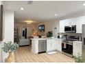 Modern kitchen featuring stainless steel appliances, white cabinetry, and an open concept design into the living area at 12231 Kirk Ave, Port Charlotte, FL 33981