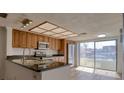 Bright kitchen featuring wood cabinetry, stainless steel appliances, and sliding glass doors at 128 1St Street E. # 102, Tierra Verde, FL 33715