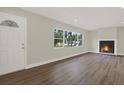 Bright living room with hardwood floors, a cozy fireplace, and large windows at 1352 Parkwood St, Clearwater, FL 33755