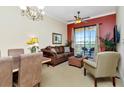 Comfortable living room featuring a ceiling fan, seating, large windows, and access to outdoor balcony at 13941 Clubhouse Dr # 308, Tampa, FL 33618