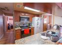 Functional kitchen with stainless steel appliances, granite counters, tile flooring, and plenty of storage at 1512 W Sitka St, Tampa, FL 33604