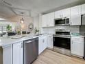 Bright, updated kitchen featuring stainless appliances, white cabinets, granite countertops, and open layout at 1701 Pinehurst Rd # 16C, Dunedin, FL 34698