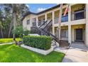 A neatly maintained condo building is accentuated by stairs, green shrubs, and expansive green lawns at 1801 E Lake Rd # 3A, Palm Harbor, FL 34685