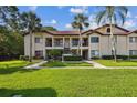 A well-manicured lawn complements this condo building with palm trees, sidewalks, and a neatly landscaped entry at 1801 E Lake Rd # 3A, Palm Harbor, FL 34685