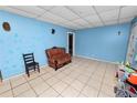 Living room with tile flooring, light blue walls, and a vintage leather sofa at 2504 Jim Johnson Rd, Plant City, FL 33566