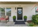 Inviting front door with blue floral wreath, plants and seating at 3418 W Bay Ave, Tampa, FL 33611