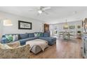 Bright living room with new floors, ceiling fan, large sectional sofa and connecting dining room at 3418 W Bay Ave, Tampa, FL 33611