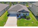 Aerial view of a well-maintained home with lush landscaping, spacious driveway, and fenced backyard at 3611 Natural Trace St, Plant City, FL 33565