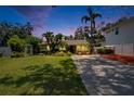Beautiful home at dusk with a verdant front yard and a spacious driveway, perfect for evening enjoyment at 3626 S Hesperides St, Tampa, FL 33629
