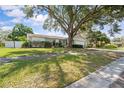 Inviting home featuring a two-car garage with manicured lawn and mature trees offering ample shade at 4120 Tyndale Dr, Brandon, FL 33511