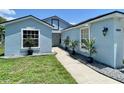 Lovely light blue single-Gathering home with a paved walkway and neatly trimmed landscaping and decorative rocks at 4214 Foxboro Dr, New Port Richey, FL 34653
