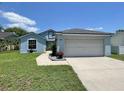 Inviting light blue single-Gathering home featuring a spacious driveway leading to an attached two-car garage at 4214 Foxboro Dr, New Port Richey, FL 34653