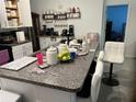 An open kitchen with a large countertop and ample storage, and modern white chairs at 4433 Eternal Prince Dr, Sun City Center, FL 33573