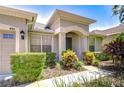 Close up of charming home's front entrance with colorful landscaping at 445 Arch Ridge Loop, Seffner, FL 33584