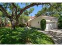 Charming home exterior featuring mature trees, lush landscaping, and a well-maintained lawn at 514 Riviera Dr, Tampa, FL 33606