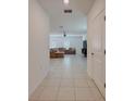 Open-concept hallway with tile flooring, providing seamless access to the inviting living room area at 6444 Bar S Bar Trl, Zephyrhills, FL 33541