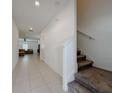 Bright hallway with tile flooring, leading to a cozy living room and stairs to the second floor at 6444 Bar S Bar Trl, Zephyrhills, FL 33541