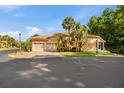 Exterior view of a home with a tile roof, two-car garage, and tropical landscaping at 7246 Gaberia Rd, New Port Richey, FL 34655