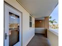 Exterior entryway featuring white door, covered walkway, and tropical landscaping in a residential building at 7465 Bay Island S Dr # 213, South Pasadena, FL 33707