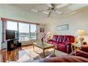 Bright living room with a large window, wood floors, ceiling fan and comfortable seating at 7465 Bay Island S Dr # 213, South Pasadena, FL 33707